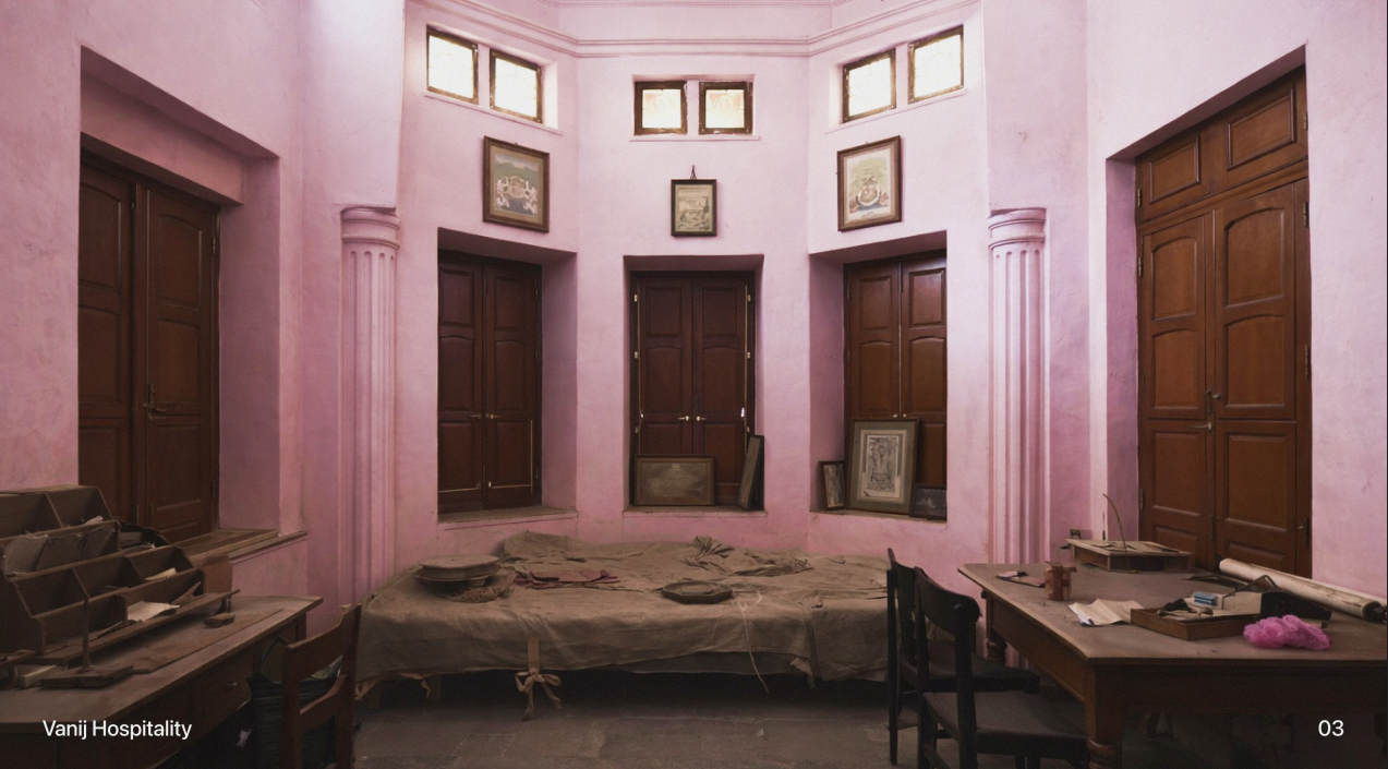 A guest room in rose lime-wash, with carved teak doors and block-printed bedding